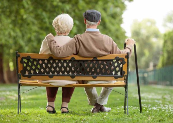 Senior couple sitting on a wooden bench in the park